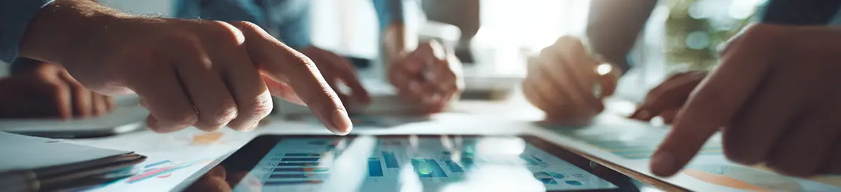 Widok z góry na dłonie zespołu pracującego przy tablecie